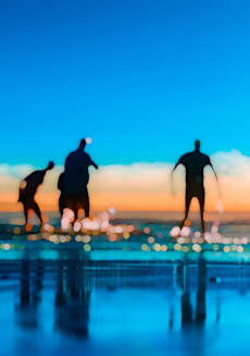 three men standing on a pier looking out over the ocean