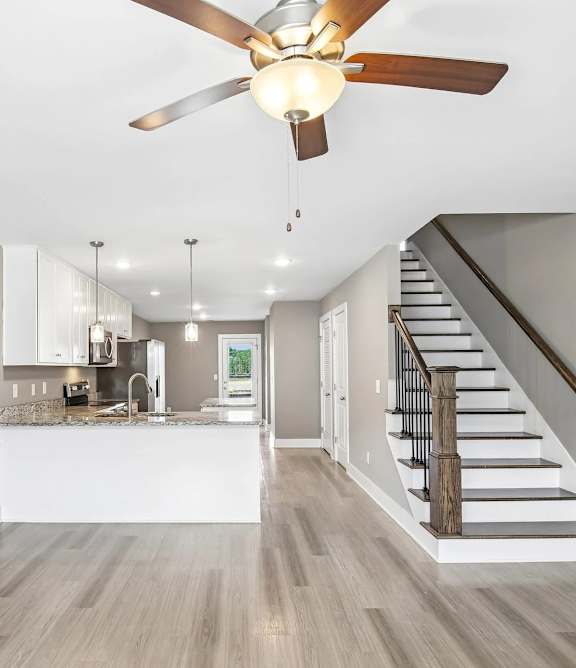 A modern kitchen with a staircase leading to the upper floor.