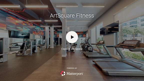 A fitness center with treadmills and a play button overlay.