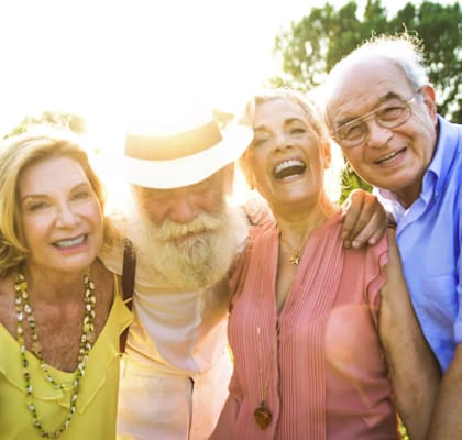 Four people posing for a photo outdoors.