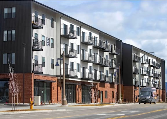 A modern apartment building with balconies and multiple stories.
