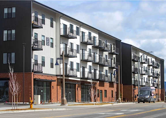 A large apartment building with balconies on the second floor.