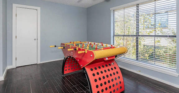 a game room with a pool table and a ceiling fan
