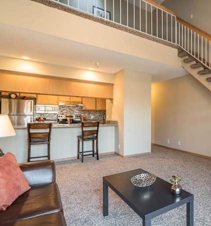 A living room with a staircase leading to the upper floor.
