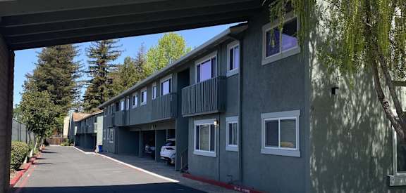 A row of houses under a bridge on a sunny day.