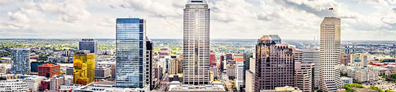 A cityscape with tall buildings and a cloudy sky.