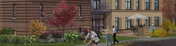 A man is riding a bicycle in front of a brick building with a sign that reads "ARMOUR".