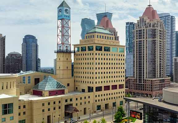 A cityscape with a variety of buildings, including a large one with a dome and a clock tower.