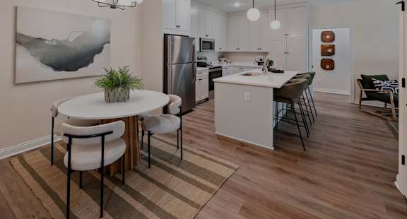 A modern kitchen with a dining table and chairs.