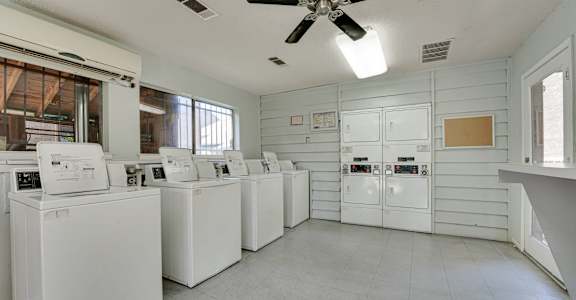 an empty laundry room with washers and dryers