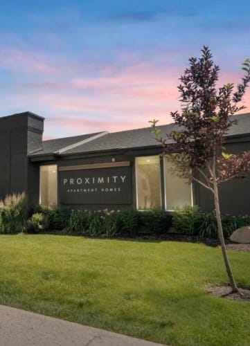 a building with a lawn and sidewalk in front of it