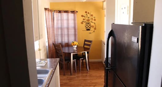 a kitchen with a table and a refrigerator