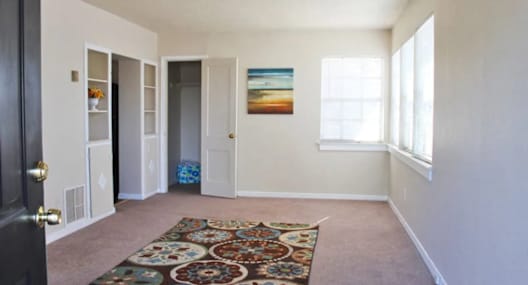 a living room with a carpet and a door that is open