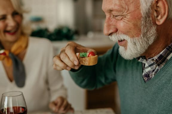 A man is holding a small cake with a green decoration on it.