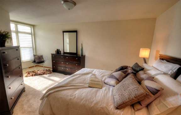 a bedroom with a bed and dresser and a window