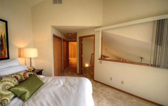 a bedroom with a bed and a hallway to a bathroom