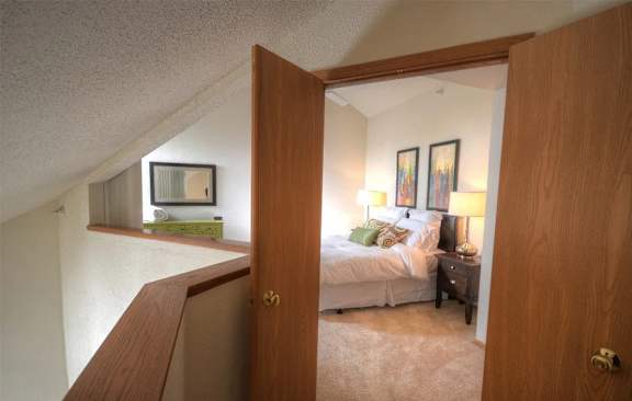 a bedroom with a bed and a mirror in a room