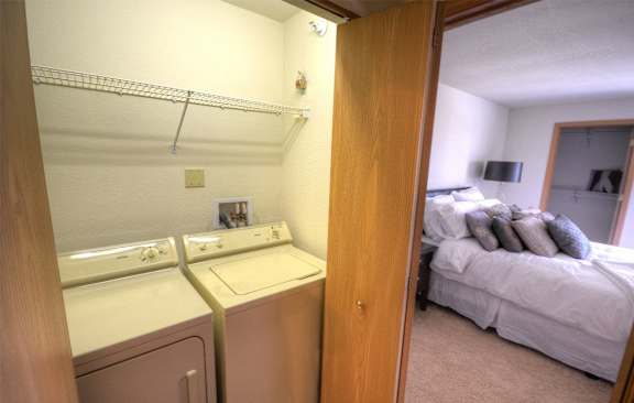 a bedroom with a washer and dryer and a bed
