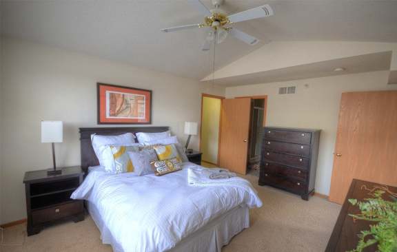 a bedroom with a large bed and a ceiling fan