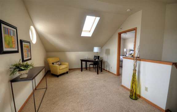 a living room with a couch and a chair and a door to a kitchen