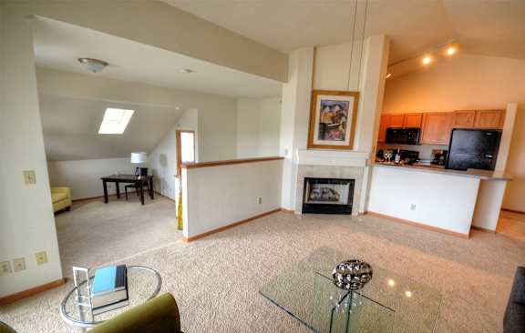 a living room with a fireplace and a glass table