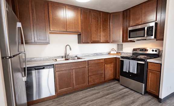A kitchen with wooden cabinets and stainless steel appliances.