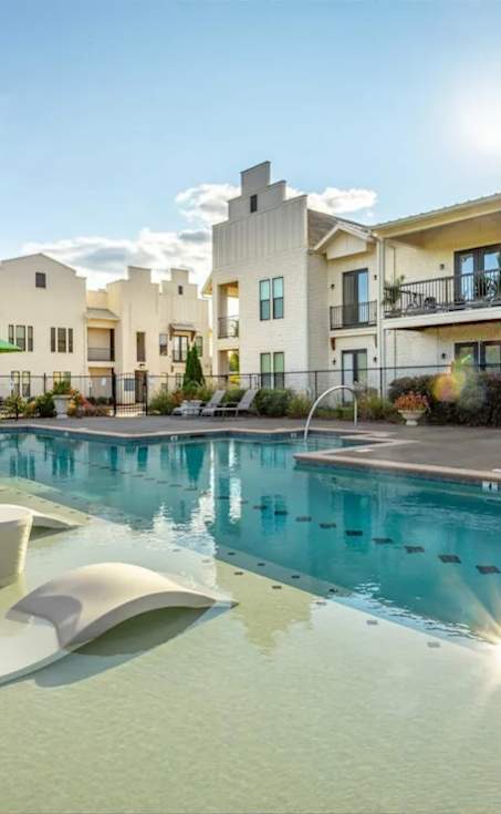 A sunny day at a modern apartment complex with a pool.