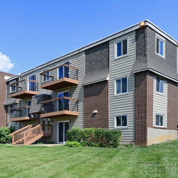 an apartment building with brick and wood balconies
