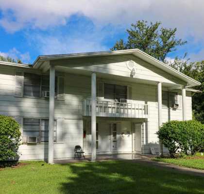a white house with a porch and a lawn at Golden Shores of Jacksonville in Jacksonville, FL 32211