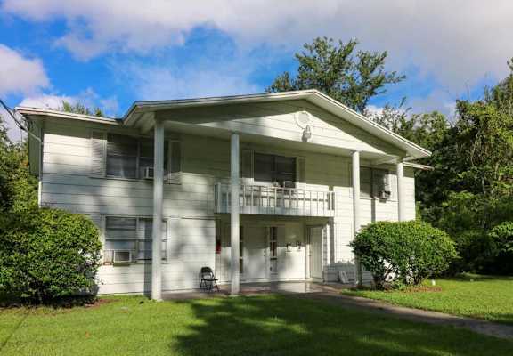 a white house with a porch and a lawn