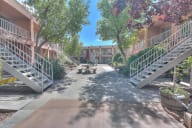 a courtyard with stairs and benches in front of an apartment building