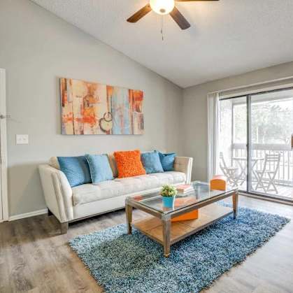 a living room with a couch and a coffee table and a sliding glass door
