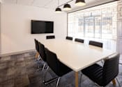Thumbnail 2 of 8 - a meeting room with a large white table and black chairs