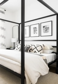 a bedroom with a bed and a black canopy bed