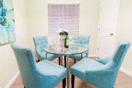 a dining room with blue chairs and a table with a vase of flowers