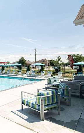 A pool area with sun loungers and umbrellas.