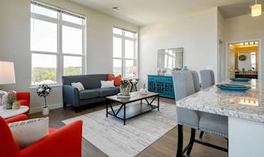 A modern kitchen with a large island and a dining area with a sofa.