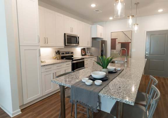 a kitchen with white cabinets and a granite counter top