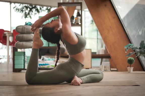 a woman doing yoga on the floor in a yoga studio