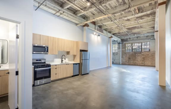 an empty kitchen with wood cabinets and stainless steel appliances