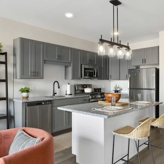 an open kitchen and living room with an island and bar stools