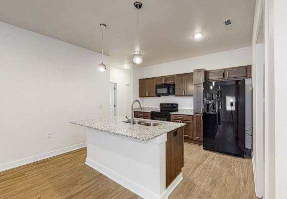 A kitchen with a granite countertop and a refrigerator.