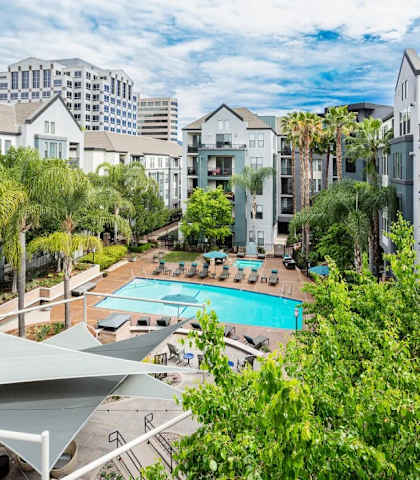 A pool surrounded by trees and buildings.