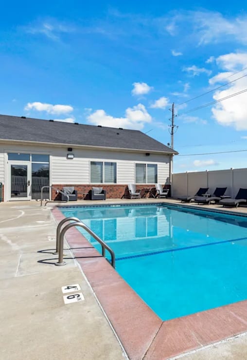 A swimming pool with a red border and a building in the background.