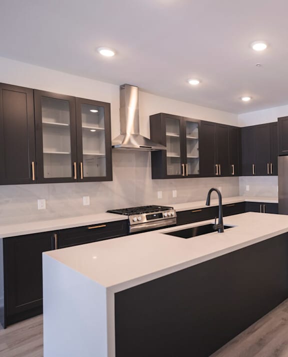 a kitchen with a white counter top and black cabinets at The Franklin at Westfield, Westfield, NJ 07090