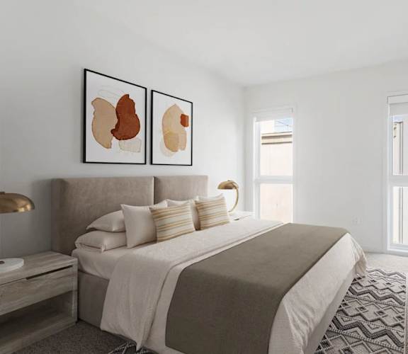 A bedroom with a large bed and two framed artworks on the wall.
