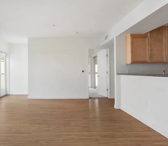 A large empty room with wooden floors and white walls.