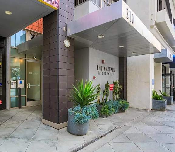 The Mayfair Residence is a modern building with a glass entrance and a sign above it.