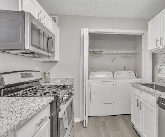 A kitchen with white cabinets and appliances.