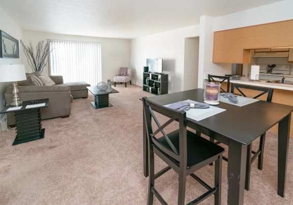 a dining room and kitchen with a table and chairs